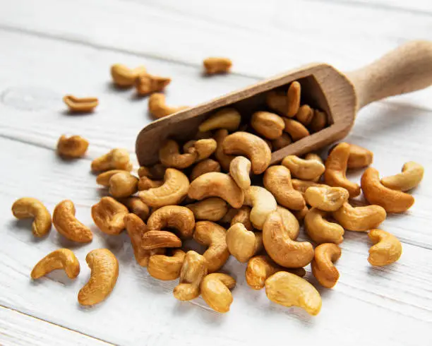 Tasty cashew nuts in scoop on a old wooden table