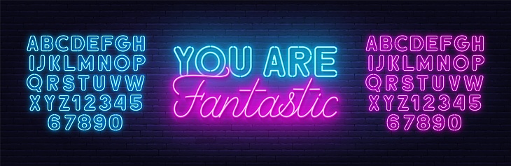 You Are Fantastic neon quote on a brick wall. Inspirational glowing lettering. Neon pink and blue alphabet.