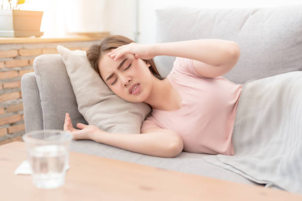 Portrait of Asian woman is holding their hand from headache lying on sofa, Young beautiful Asian woman on sofa having headache / migraine / stress / sick Portrait of Asian woman is holding their hand from headache lying on sofa, Young beautiful Asian woman on sofa having headache / migraine / stress / sick head ache stock pictures, royalty-free photos & images