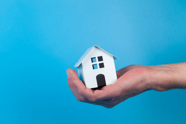 istock Hand with a toy house. 1365768609