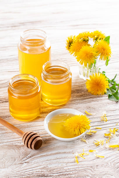 istock Dandelion honey in a jar and fresh flowers on a table 1365769999