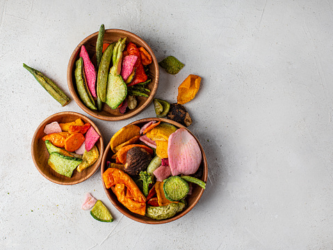 Vitamin healthy fast food with carrot slices, beetroot wedges, broccoli, zucchini on a light table. food photo banner copy space.