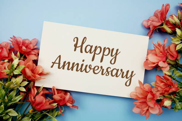 istock Happy Anniversarytext with flower frame on blue background 1365774175