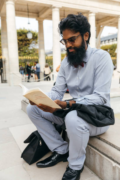 istock Business breaks. A young man relaxing reading a book 1365774440