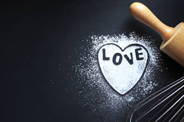 istock Black background with rolling pin, text love, wire whisk and heart shape on wooden table with a place for text or images.valentine day or mother's day concept 1365776463