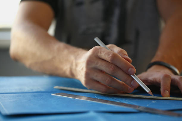 istock Builder man hand holding pencil and make corrections on building plan 1365777081