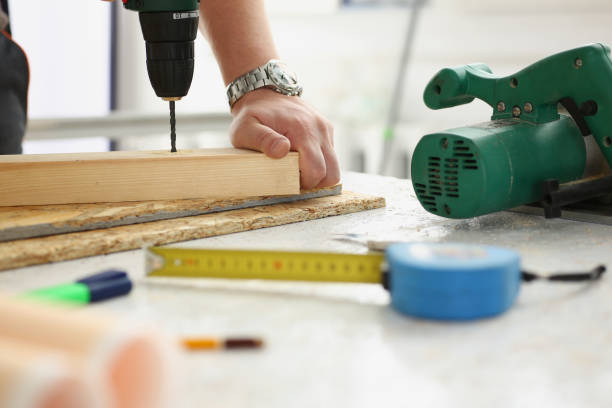 istock Workers instruments for repairing, man drill hole in wooden plank 1365777087