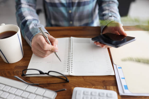 istock Person start day right with planner and cup of coffee, make appointment, plan 1365777608
