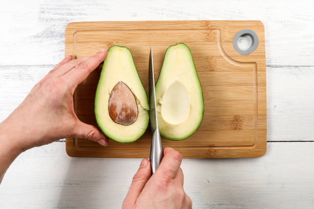 istock Cut in half the avocado fruit on a bamboo cutting board. Organic food 1365781512