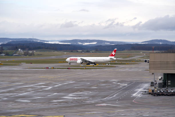 aéroport suisse zurich kloten avec fond de ciel nuageux. - runway airport sky wet photos et images de collection