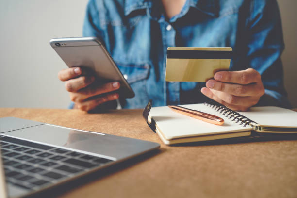 istock Hands holding credit card with using laptop. 1365784074