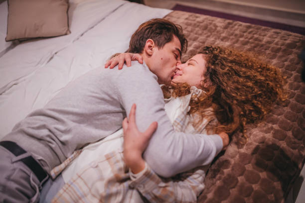 istock Couple in love lying down on bed in hotel room 1365786930