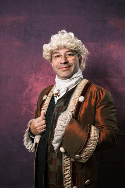 istock Man in classical renaissance clothing looking at camera while posing against an isolated background. 1365789803