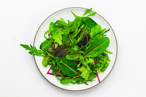 A plate with fresh salad of beet, lettuce, spinach, arugula foliage and radish microgreen. Mangold or swiss chard greens, arugula, lettuce and daikon radish sprouts. Healthy food, dieting concept.
