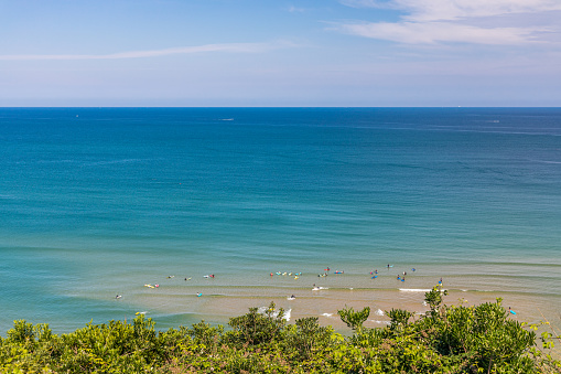 Atlantic Ocean with surfers waiting for a good wave to surf at Cote des Basques beach in Biarritz, France