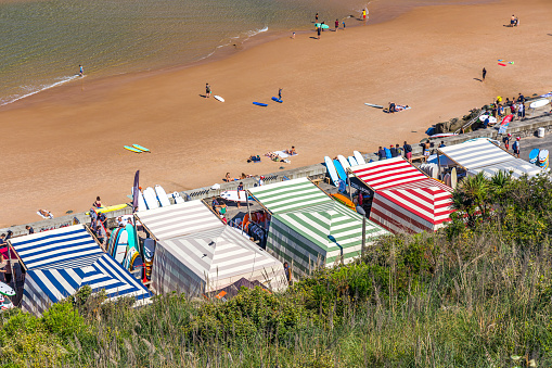 Cote des Basques beach in Biarritz with surf school tents set up along the seaside, France