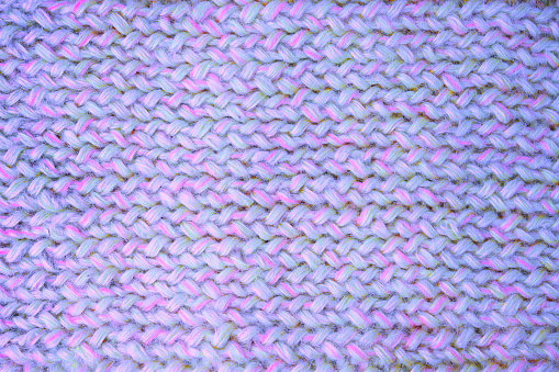 Knitwear in velvet purple with calm pink is on the table - this is the fashionable color trend of 2022. View from above