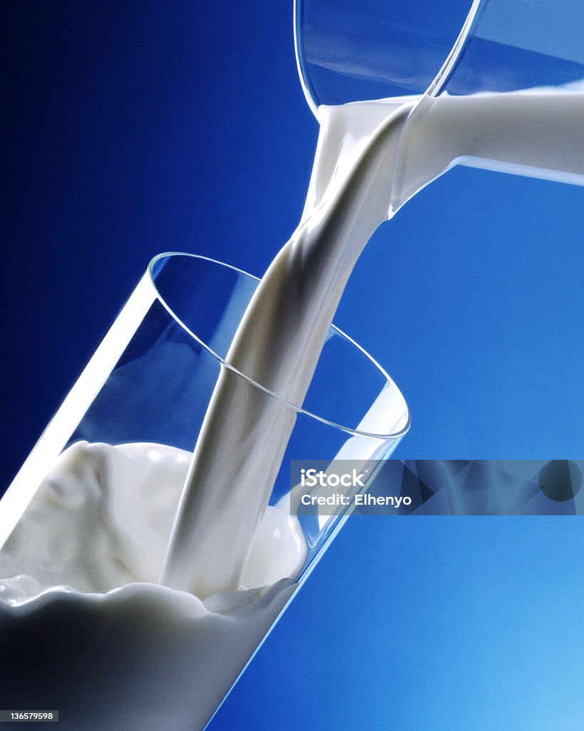 Versare in un bicchiere di latte - Foto stock royalty-free di Bibita