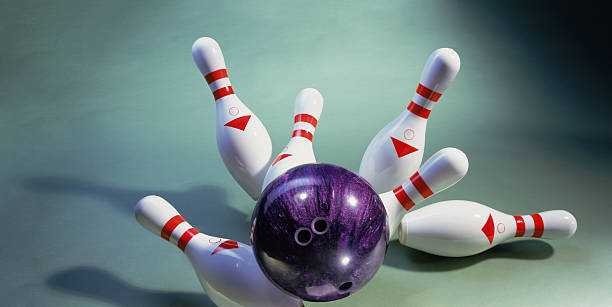 istock A purple bowling ball knocking over pins 136579972