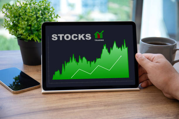 istock male hands holding computer tablet with stocks trading app 1365801603