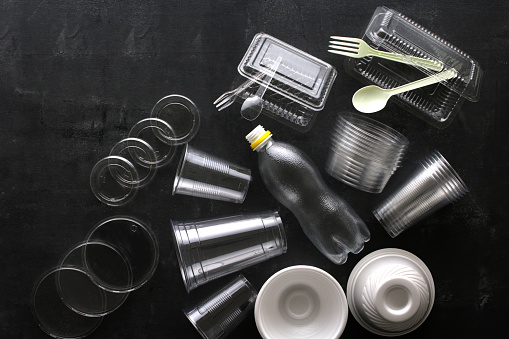 Productos de plástico en vasos y recipientes transparentes tomados sobre un fondo oscuro photo