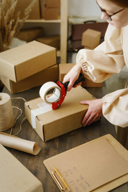 istock Woman packaging box for delivery. Business Startup Ideas. 1365811422