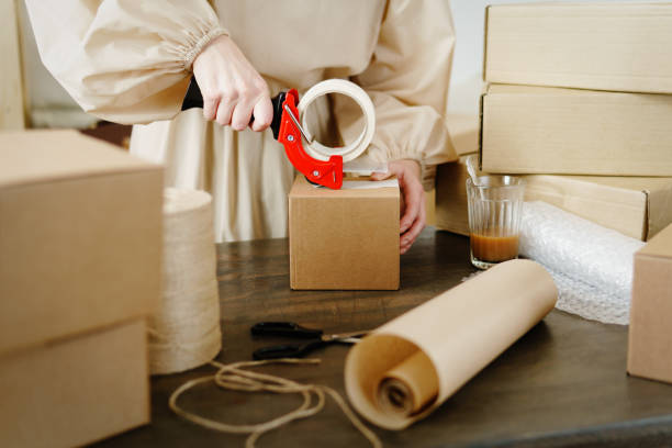 istock Woman packaging box for delivery. Business Startup Ideas. 1365811439