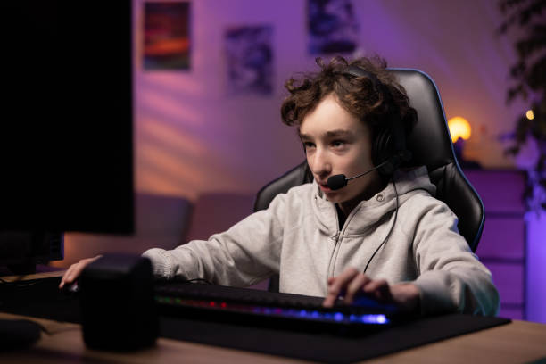 istock School-age boy pro gamer spends time playing computer games, focused child has headset to talk to team, room lit with neon, led lights, gaming accessories 1365812790