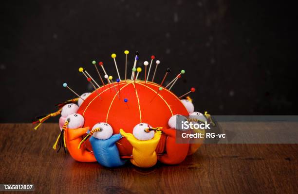 Red Pincushion With Colorful Pins On Wooden Table And Dark Background Stock Photo - Download Image Now