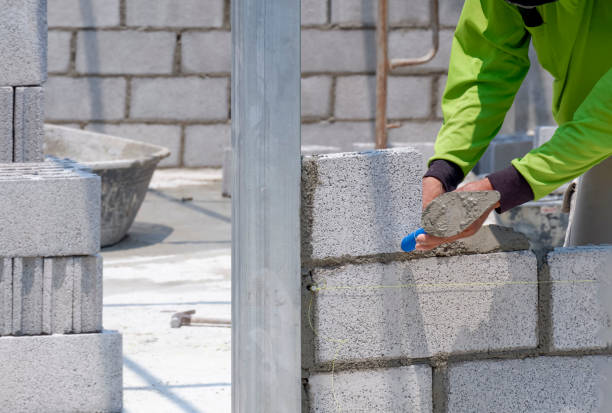 istock Bricklayer hand using trowel to making brick wall inside of house construction site 1365812927