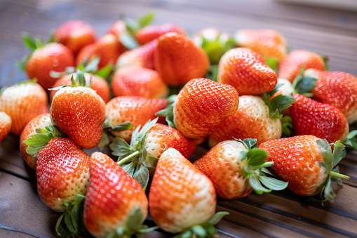 Some freshly picked strawberries, stacked on the table. medium shot with a Canon R5.