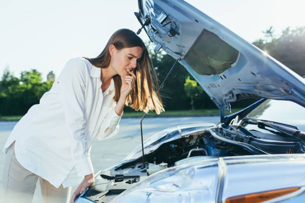 istock Confused woman examines the car engine 1365815164