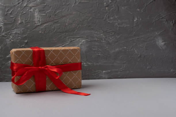 istock Gift box with red ribbon on grey background. 1365816419