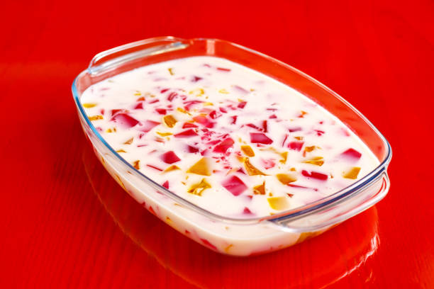 fruit yogurt in a ceramic bowl with spoon on a light background, selective focus.