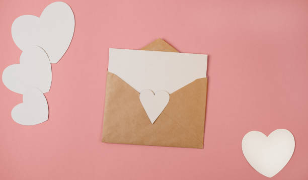 bastelumschlag mit leerem weißem note-mockup innen und valentinsherzen auf rosa hintergrund. - liebesgruß stock-fotos und bilder