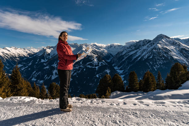 istock Woman standing on mountain hill and looking at the map. 1365817855