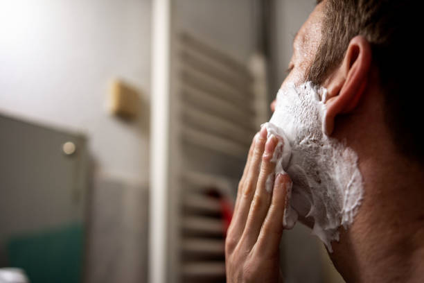 istock Young man applying shaving cream over his face 1365819959