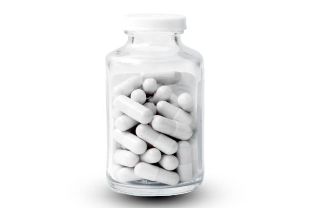 istock isolated on a white background glass jar with pills. 1365820702