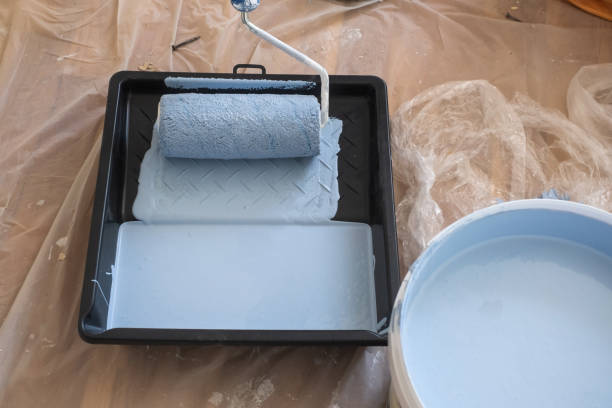 istock Paint roller and tray with paint on a floor 1365820888