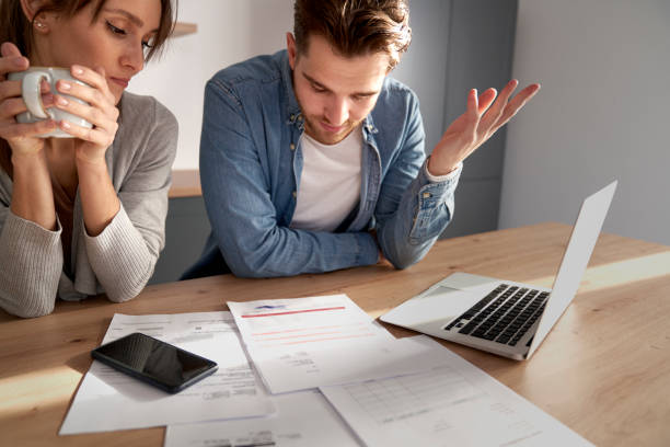 Miserable young caucasian couple having financial problems due to new house Miserable young caucasian couple having financial problems due to new house bust stock pictures, royalty-free photos & images