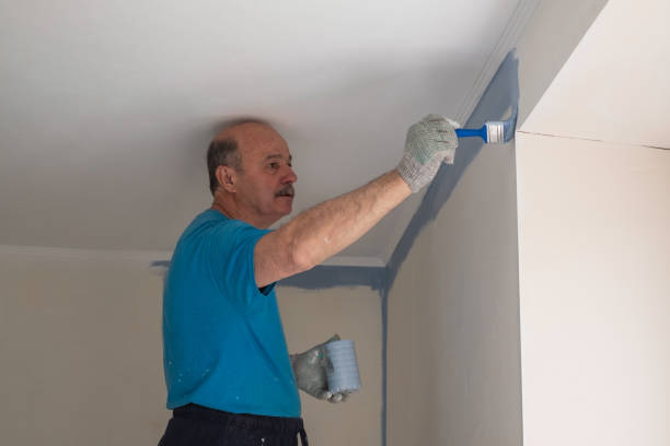 istock Worker painting walls with a brush during flat renovation 1365822342