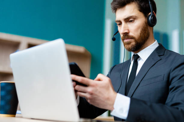 istock Businessman sitting at computer desk in the office with microphone headset 1365822419