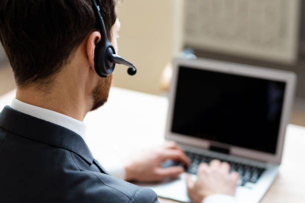 istock Businessman sitting at computer desk in the office with microphone headset 1365822963