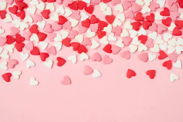 Photo of Many colorful sugar hearts on pink background with copy space
