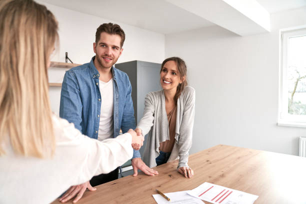 Handshake of real estate agent and young caucasian couple Handshake of real estate agent and young caucasian couple vendor stock pictures, royalty-free photos & images