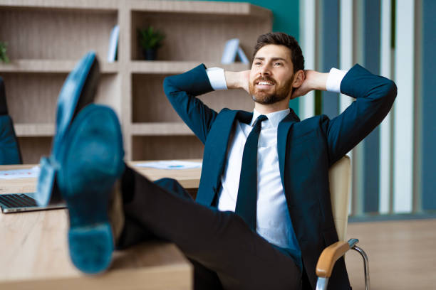 istock Businessman sitting at computer desk in the office relaxing 1365824663