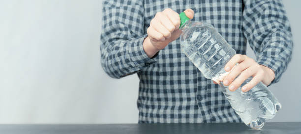 istock the boy opens a bottle of clean drinking water. 1365824853