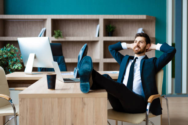 istock Businessman sitting at computer desk in the office relaxing 1365825203
