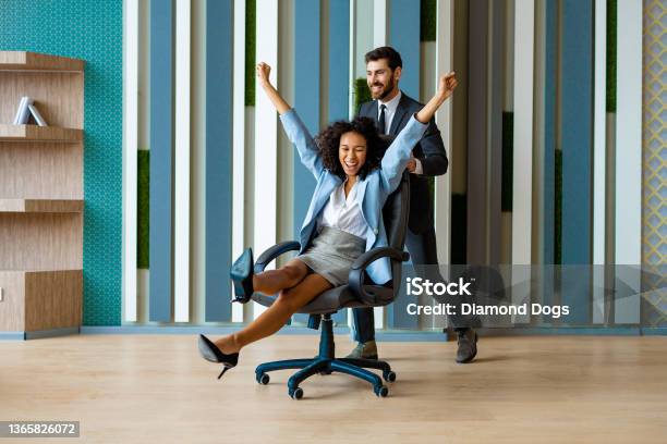 Happy And Playful Business People Stock Photo - Download Image Now - Office Chair, Fun, Business Person