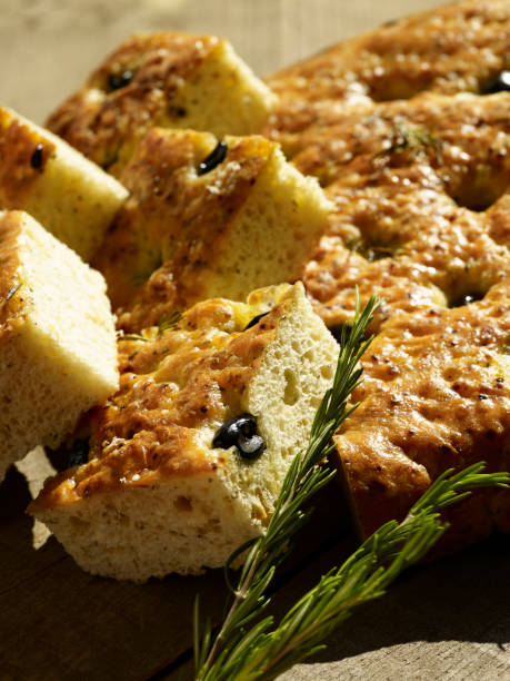 istock Focaccia bread sliced and served with fresh greens and herbs 1365826655